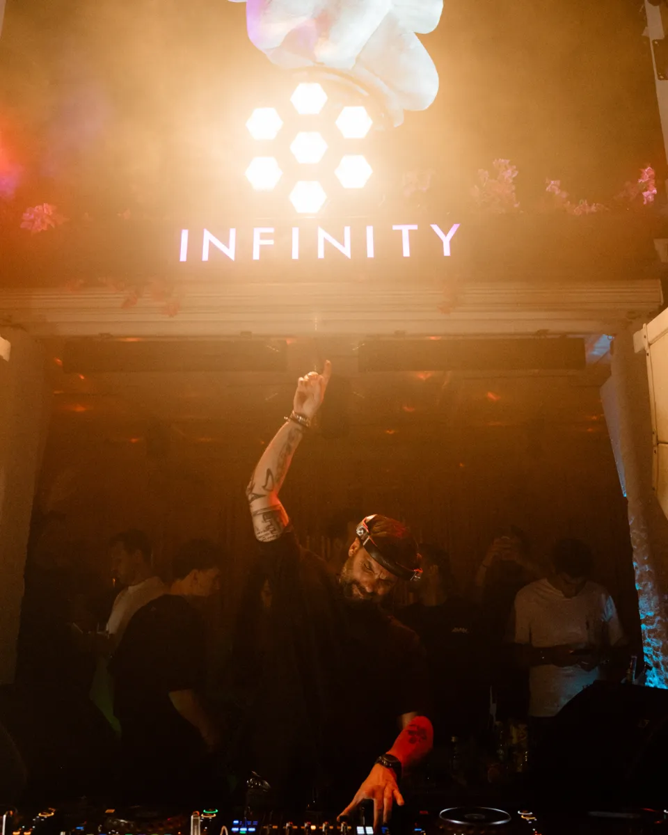 DJ performing beneath the Infinity sign at Island club